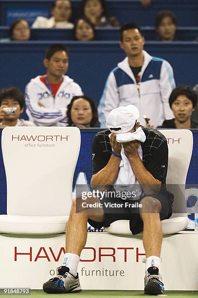 Andy Rodick of the United States towels off while waiting for a trainer to come on court to examine his knee before eventually retiring from his...