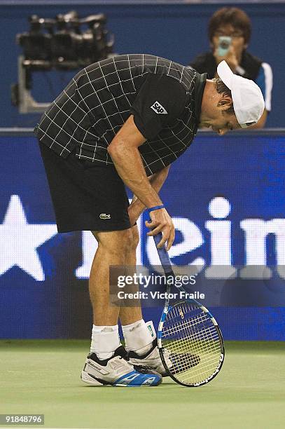 Andy Rodick of the United States examines his knee before retiring from his match against Stanilas Wawrinka of Switzerland during day three of 2009...