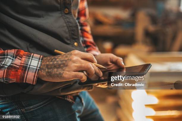 tischler mit tablette während der arbeit in seiner werkstatt-pn-möbel-projekt - schreiner tablet stock-fotos und bilder