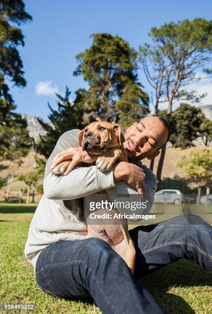 junger mann mit seinem hund im park spielen. - boerboel stock-fotos und bilder