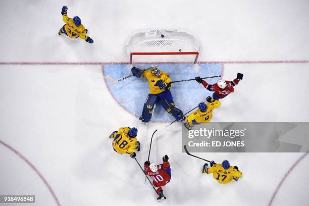 Players react as a puck shot by Norway's Ken Andre Olimb bounces off Sweden's Viktor Fasth into the net in the men's preliminary round ice hockey...