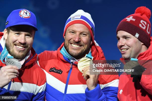 Norway's silver medallist Kjetil Jansrud, Norway's gold medallist Aksel Lund Svindal and Switzerland's bronze medallist Beat Feuz pose on the podium...
