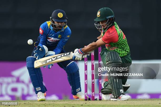 Bangladesh cricketer Zakir Hasan bats as the Sri Lanka wicketkeeper Niroshan Dickwella looks on during the first Twenty20 cricket match between...