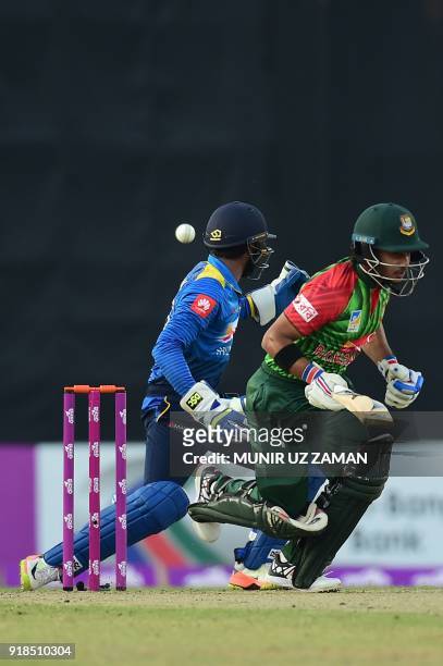 Bangladesh cricketer Zakir Hasan bats as Sri Lanka wicketkeeper Niroshan Dickwella looks on during the first Twenty20 cricket match between...
