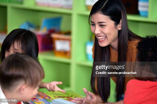 teachers and child  having fun on learning  in an international school library.teacher ,education, kid concept . - portrait of school children and female teacher in field stock pictures, royalty-free photos & images