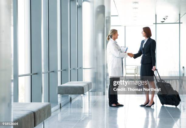 doctor greeting pharmaceutical rep in lobby - medical sales representative stock pictures, royalty-free photos & images