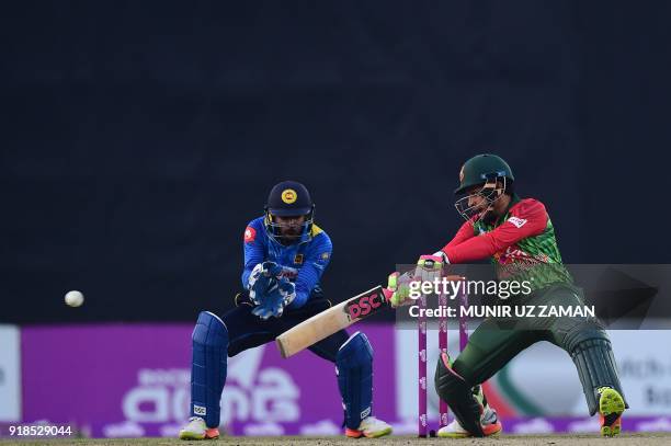 Bangladesh cricketer Mushfiqur Rahim bats as the Sri Lanka wicketkeeper Niroshan Dickwella looks on during the first Twenty20 cricket match between...