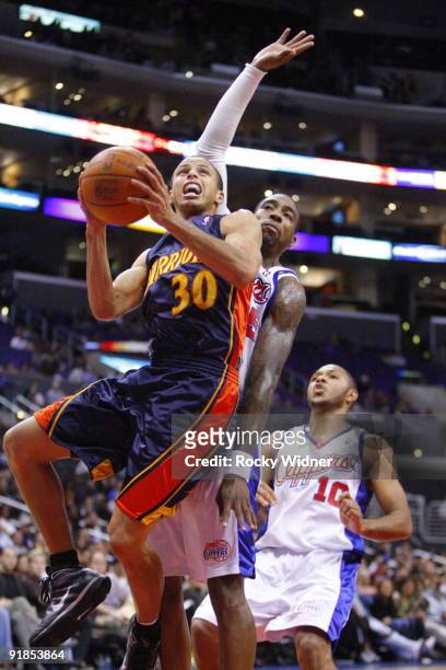 Stephen Curry of the Golden State Warriors gets to the basket against DeAndre Jordan of the Los Angeles Clippers during an NBA preseason game on...