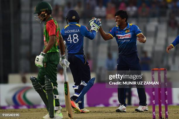 Sri Lanka cricketer Jeevan Mendis celebrates with his teammate Niroshan Dickwella after the dismissal of the Bangladesh cricketer Afif Hossain during...