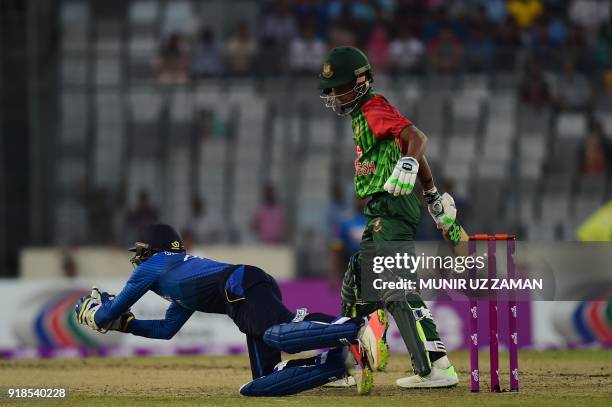 Sri Lanka cricketer Niroshan Dickwella takes a catch successfully to dismiss Bangladesh cricketer Afif Hossain during the first Twenty20 cricket...