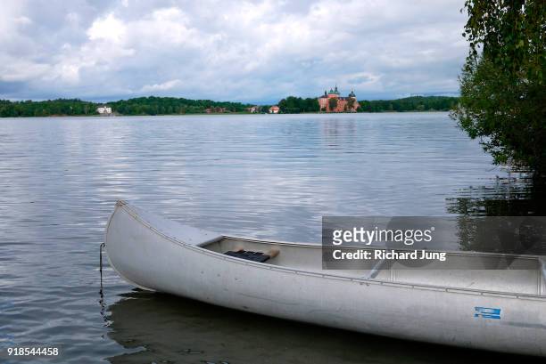 canoe on swedish lake with castle in background. - aluminium boat fotografías e imágenes de stock