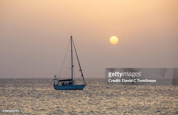 lone yacht anchored off playa mujeres, sunset, playa blanca, lanzarote, canary islands, spain - mujeres hot stock pictures, royalty-free photos & images