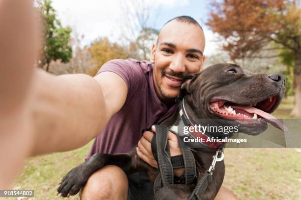 jonge man opknoping met zijn hond nemen van selfies. - paarse riem stockfoto's en -beelden