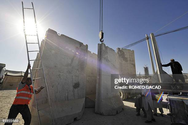 Afghan workers deliver 18 solid concrete blast barriers at the Kandahar military base on October 13, 2009. The local supplier said the four meter by...