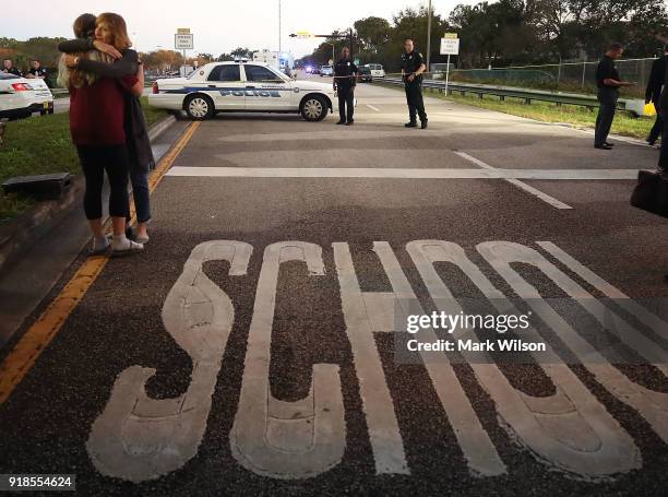 Kristi Gilroy , hugs a young woman at a police check point near the Marjory Stoneman Douglas High School where 17 people were killed by a gunman...