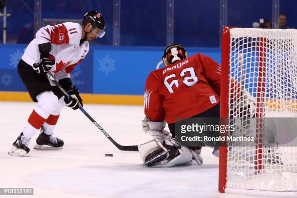 Chris Kelly of Canada makes a shot on Leonardo Genoni of Switzerland during the Men's Ice Hockey Preliminary Round Group A game on day six of the...