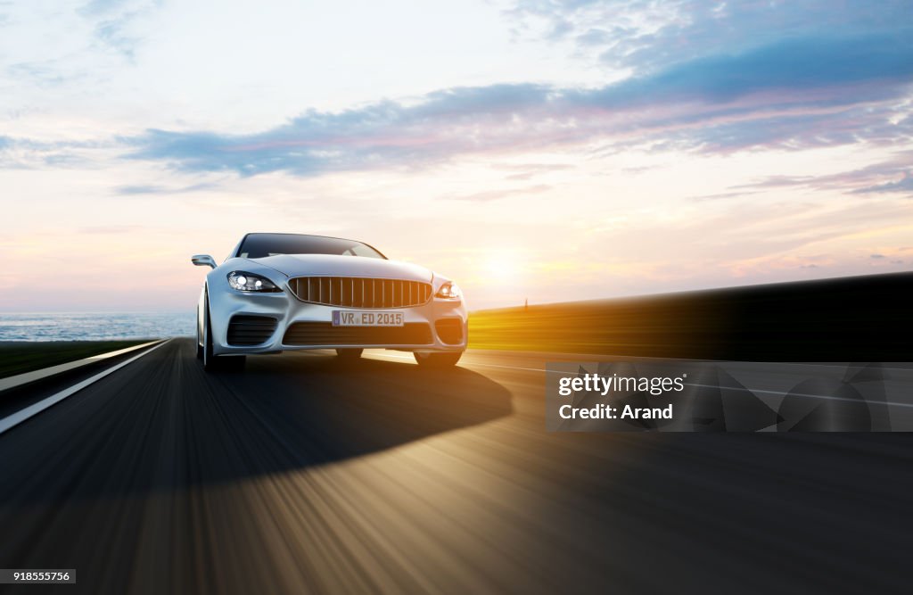 Car driving on a road by sea