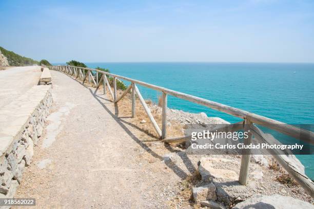 wooden fence surrounding dirt road overlooking the mediterranean sea, peniscola, spain - costa_del_azahar stock pictures, royalty-free photos & images