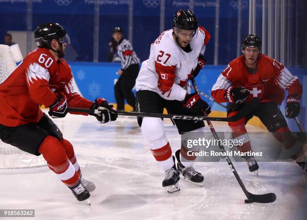 Cody Goloubef of Canada skates against Tristan Scherwey of Switzerland in the second period during the Men's Ice Hockey Preliminary Round Group A...