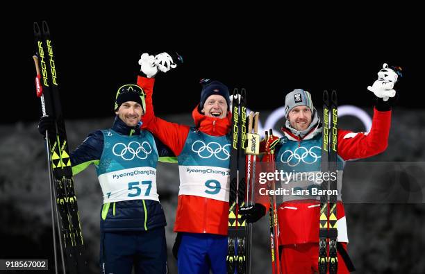 Gold medallist Johannes Thingnes Boe of Norway celebrates with silver medallist Jakov Fak of Slovenia and bronze medallist Dominik Landertinger of...