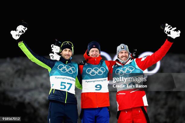 Gold medallist Johannes Thingnes Boe of Norway celebrates with silver medallist Jakov Fak of Slovenia and bronze medallist Dominik Landertinger of...