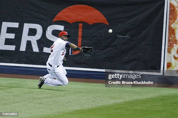 Denard Span of the Minnesota Twins slides to catch a fly ball hit by the Kansas City Royals on October 3, 2009 at the Metrodome in Minneapolis,...