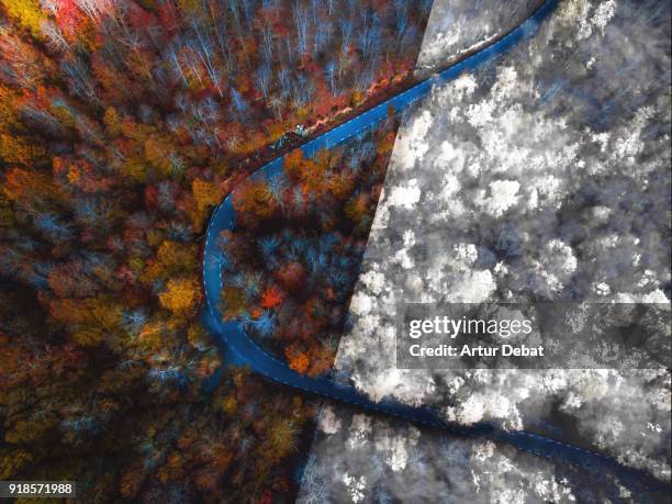 comparison picture taken from drone with half autumn and half winter landscape. - autoreifen natur stock-fotos und bilder