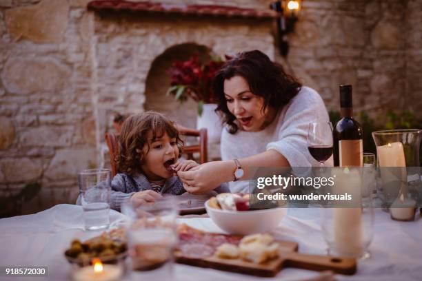 grossmutter und junge enkel am traditionellen cottage esstisch - spain italy stock-fotos und bilder