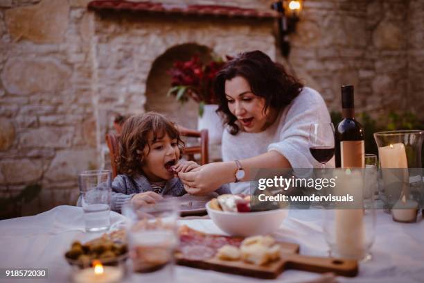grandmother and young grandson at traditional cottage dinner table - italian family restaurant stock pictures, royalty-free photos & images