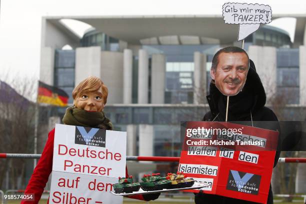 Peace Activist wearing masks showing Erdogan and Merkel faces show Toy Tanks to protest against the the weapons deal between Germany and Turkey ahead...