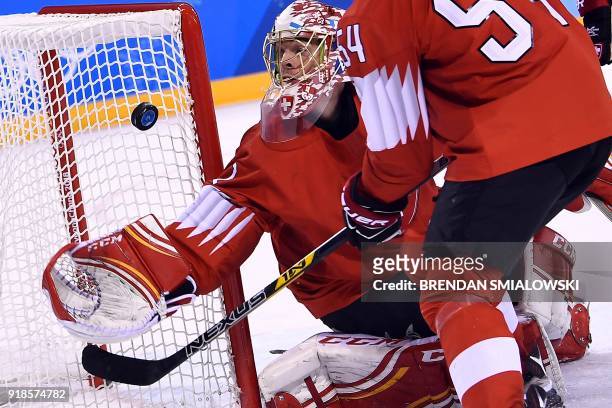 Switzerland's Jonas Hiller stops a puck in the men's preliminary round ice hockey match between Switzerland and Canada during the Pyeongchang 2018...