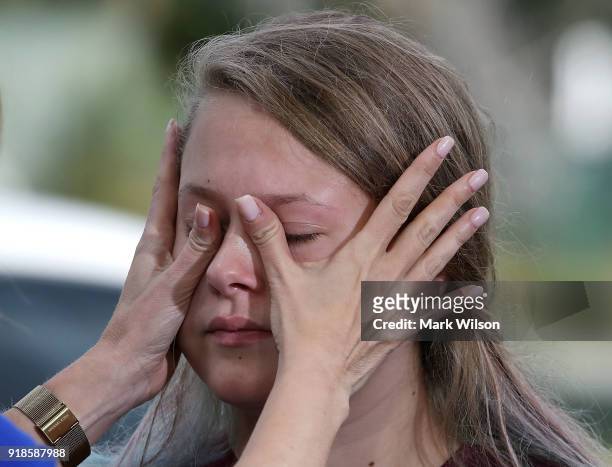 Student Kelsey Friend, gets help wiping away her tears after recounting her story about yesterday's mass shooting at the Marjory Stoneman Douglas...