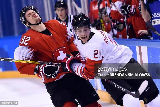 Switzerland's Gaetan Haas and Canada's Mason Raymond clash in the men's preliminary round ice hockey match between Switzerland and Canada during the...