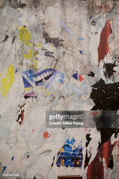 Torn posters on an underground station wall in London, England, United Kingdom.