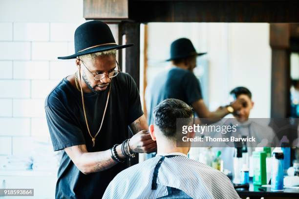 barber trimming clients bangs during hair cut in barber shop - barber fotografías e imágenes de stock