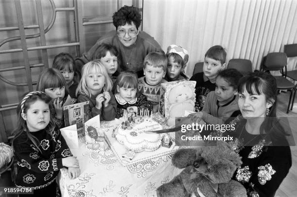 Mrs Lesley Holmes , leader of St John's playgroup in Golcar, is pictured with Mrs Catherine Nethercoats - who made the birthday cake - and the...