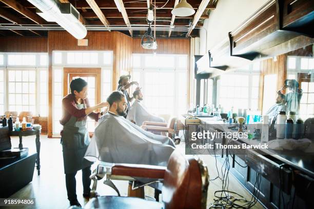 clients having their hair cut in barber shop - barber fotografías e imágenes de stock