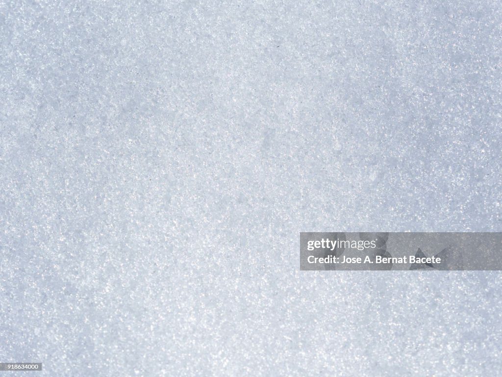 Background Full frame of snow covered ground illuminated by sunlight. Spain