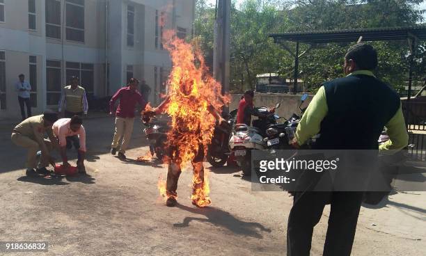 Indian police officials begin efforts to save Bhanubhai Vankar, who set himself on fire outside the Patan district collector's office at Patan town,...
