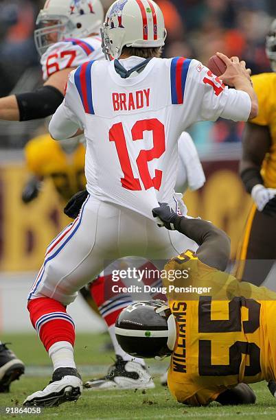 Linebacker D.J. Williams of the Denver Broncos gets a fist full of the jersey of quarterback Tom Brady of the New England Patriots as he tries to get...