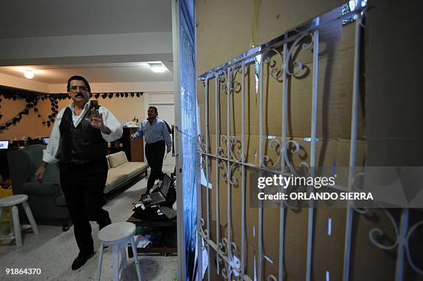 Toppled Honduran President Manuel Zelaya waves to the porss before meeting with his advisors inside the Brazilian embassy in Tegucigalpa, on October...