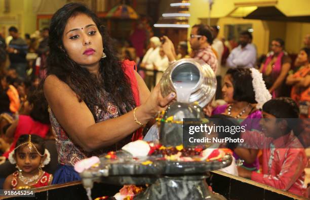 Tamil Hindu woman offers prayers by pouring milk over a Shiva Lingam during the Maha Shivratri festival at a Tamil Hindu temple in Ontario, Canada,...