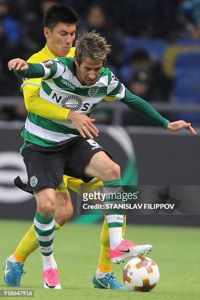 Astana's defender Abzal Beisebekov vies with Sporting's defender, Fabio Coentrao during the Europa League Round of 32 first leg football match...