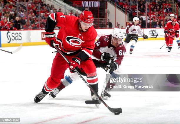 Victor Rask of the Carolina Hurricanes controls the puck away from the defense of Nail Yakupov of the Colorado Avalanche during an NHL game on...