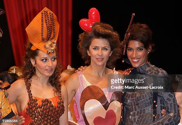 Coralie Clement and Corinie Touzet and Laurie Cholewa displays a chocolate decorated dress during the Chocolate dress fashion show celebrating Salon...
