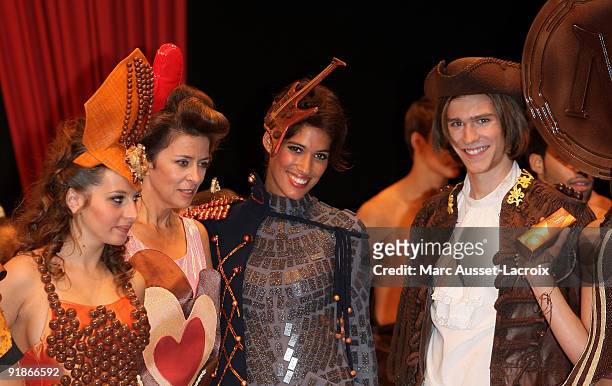 Coralie Clement and Corinne Touzet and Laurie Cholewa displays a chocolate decorated dress during the Chocolate dress fashion show celebrating Salon...