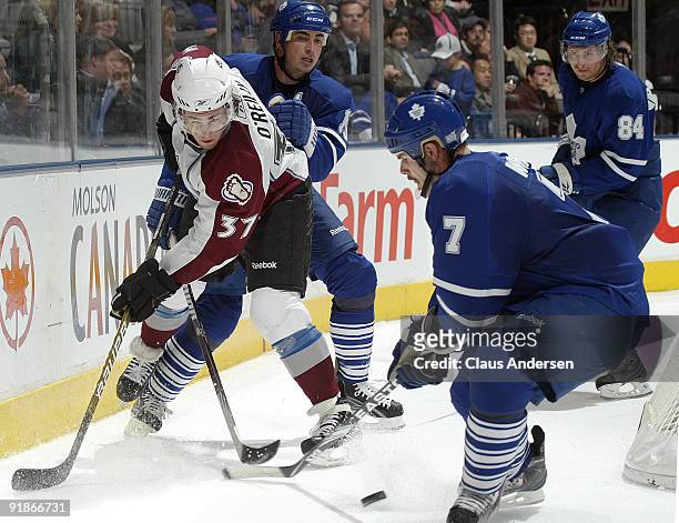 Ryan O'Reilly of the Colorado Avalanche tries to flip the puck past Ian White of the Toronto Maple Leafs in a game on October 13, 2009 at the Air...
