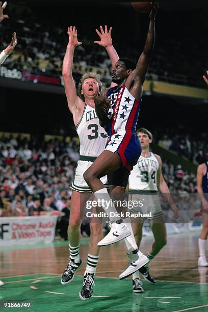 Albert King of the New Jersey Nets goes up for a shot against Larry Bird of the Boston Celtics during a game played in 1986 at the Boston Garden in...