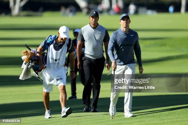 Tiger Woods and Rory McIlroy of Northern Ireland walk across the 17th hole during the first round of the Genesis Open at Riviera Country Club on...