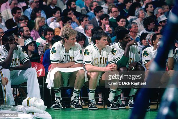 Larry Bird, Rick Carlisle and Robert Parish of the Boston Celtics sit on the bench during a game played in 1986 at the Boston Garden in Boston,...